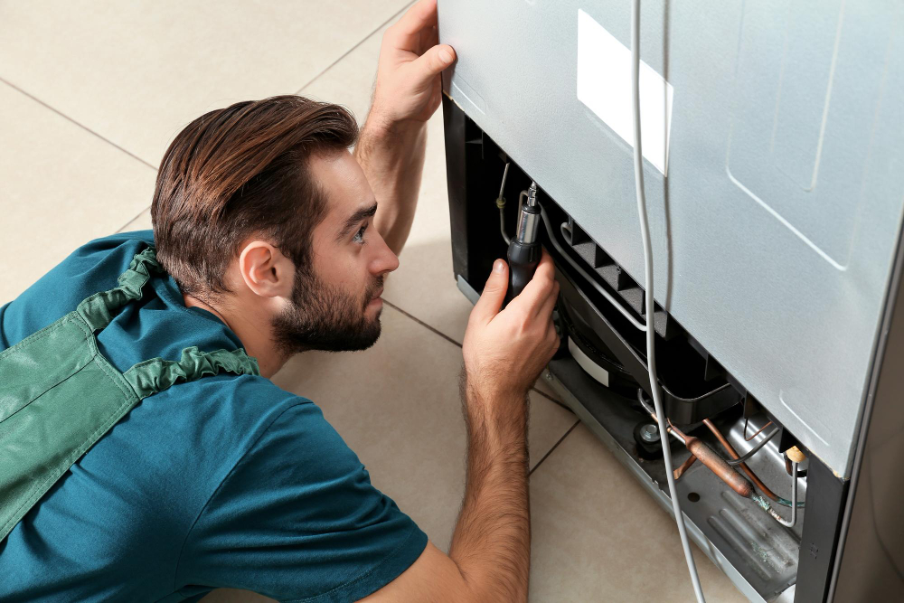 Técnico realizando manutenção em geladeira
